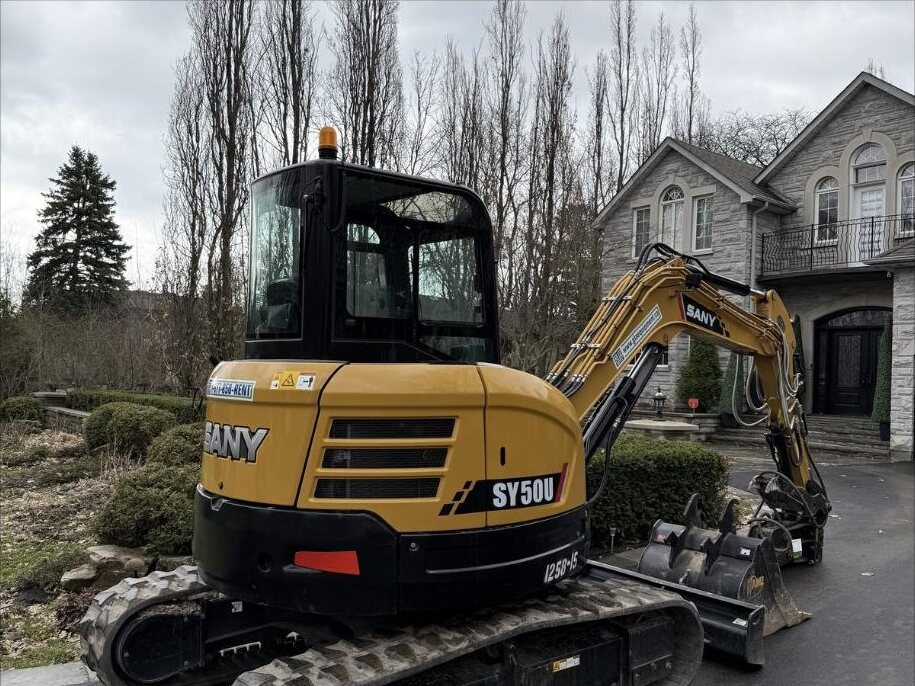 SANY SY50U mini excavator with a hydraulic thumb from GTA Equipment Rentals parked on a residential driveway in the west GTA
